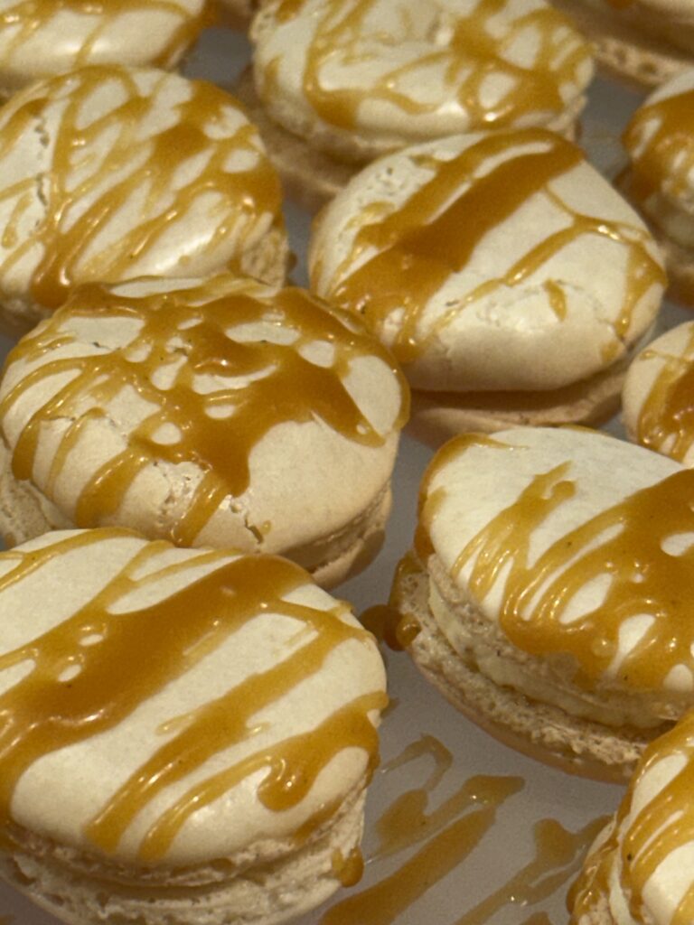 Vanilla white chocolate macarons with a caramel drizzle